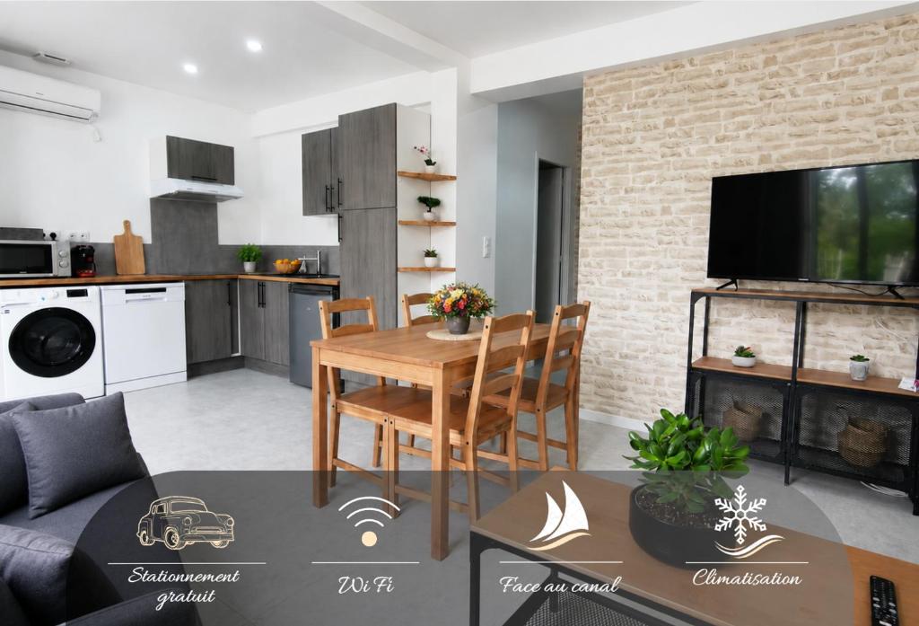 a living room with a table and a kitchen at Le temps d'une pause -3- in Cepoy