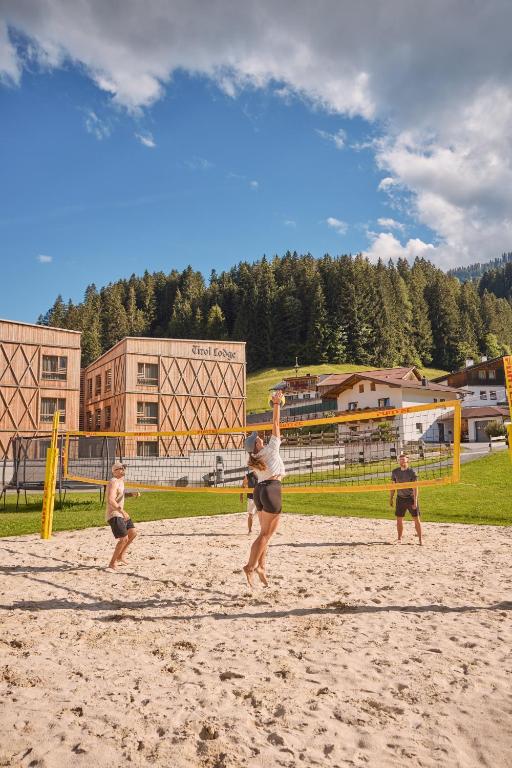 a group of people playing a game of volleyball on a beach at Tirol Lodge in Ellmau