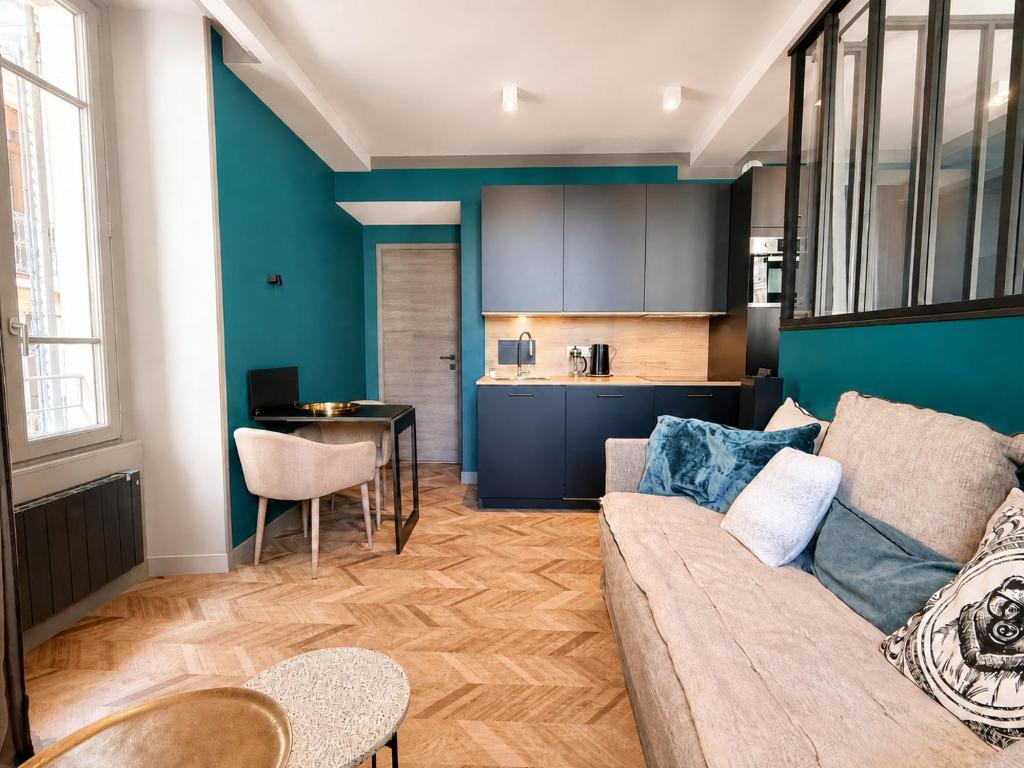 a living room with a couch and a kitchen at La Loge AL'AIX in Aix-les-Bains