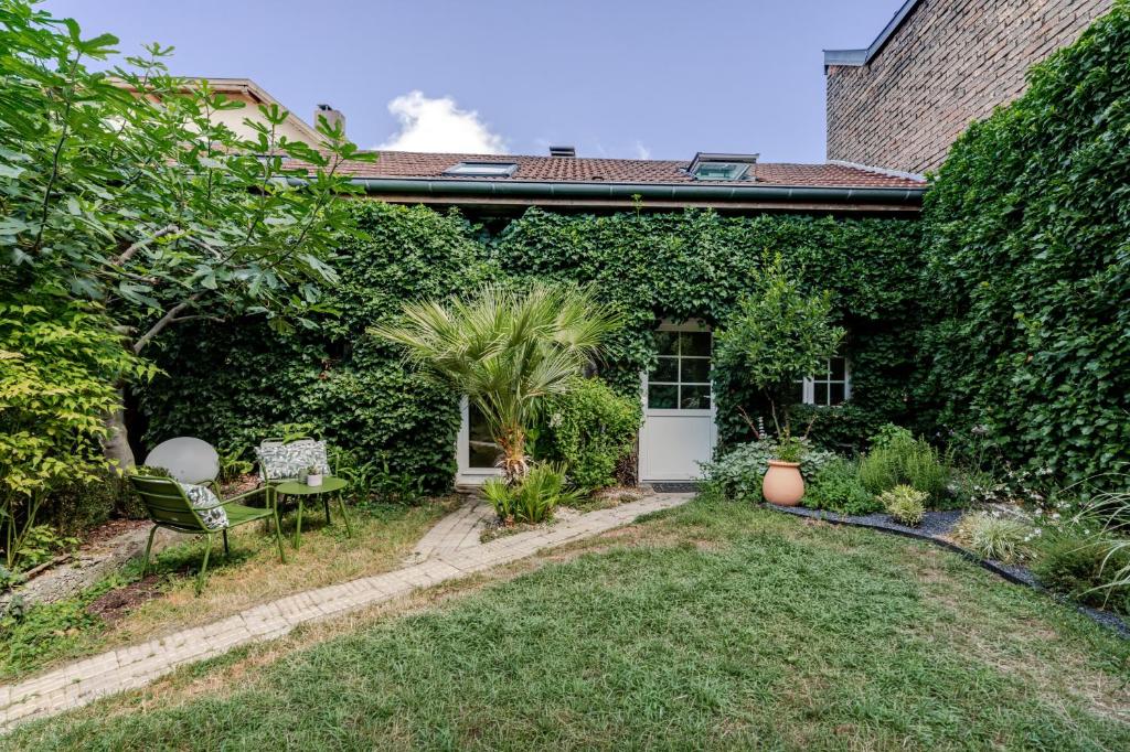 a house with a yard with a table and chairs at Cocon au fond du jardin in Souffelweyersheim
