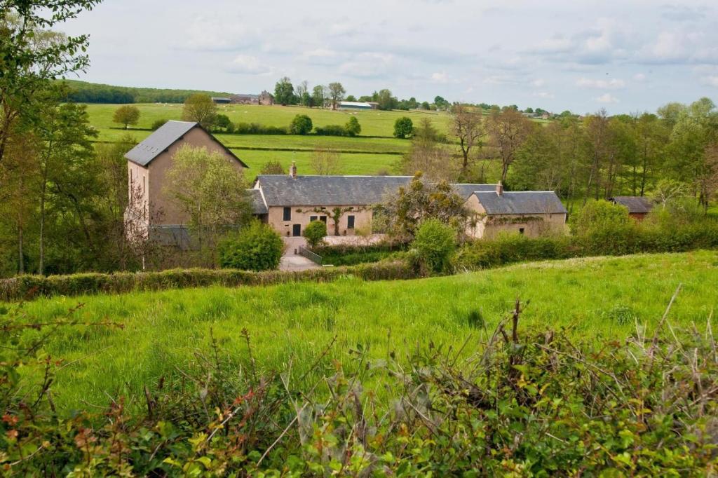 an old house in the middle of a green field at Le Moulin de Commagny in Moulins-Engilbert
