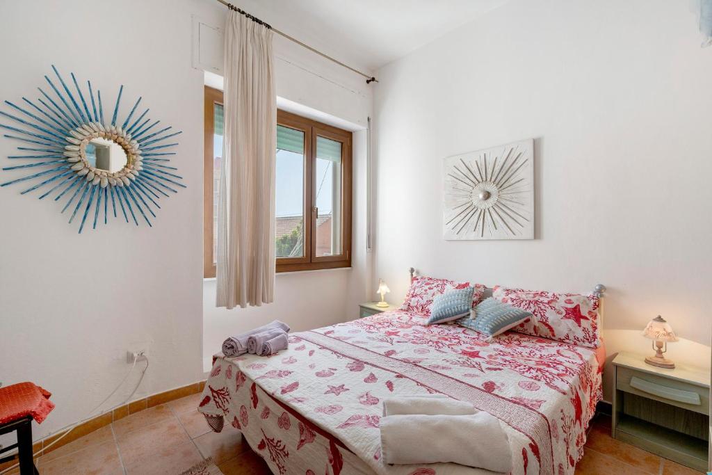 a bedroom with a bed and a mirror on the wall at Casa Silvia trilo calagavetta in La Maddalena