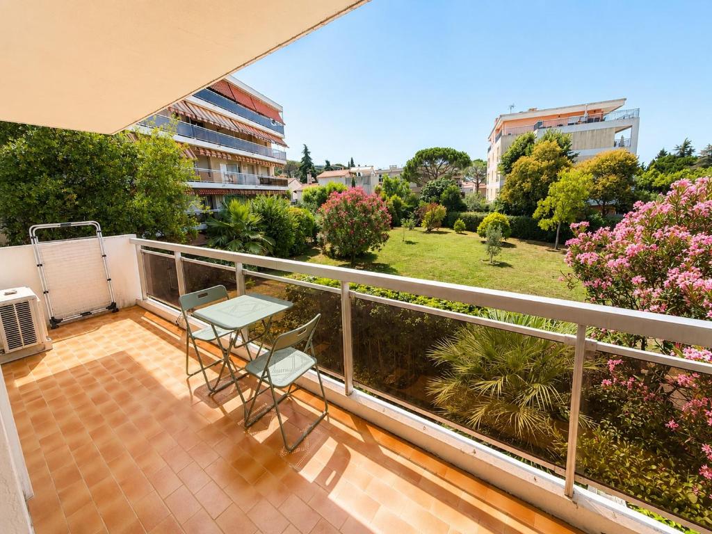 a balcony with a table and chairs and a garden at Résidence Riviera Parc in Cagnes-sur-Mer