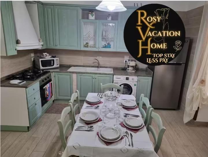 a kitchen with a table with plates and glasses on it at Rosy Vacation Home in Monte di Procida
