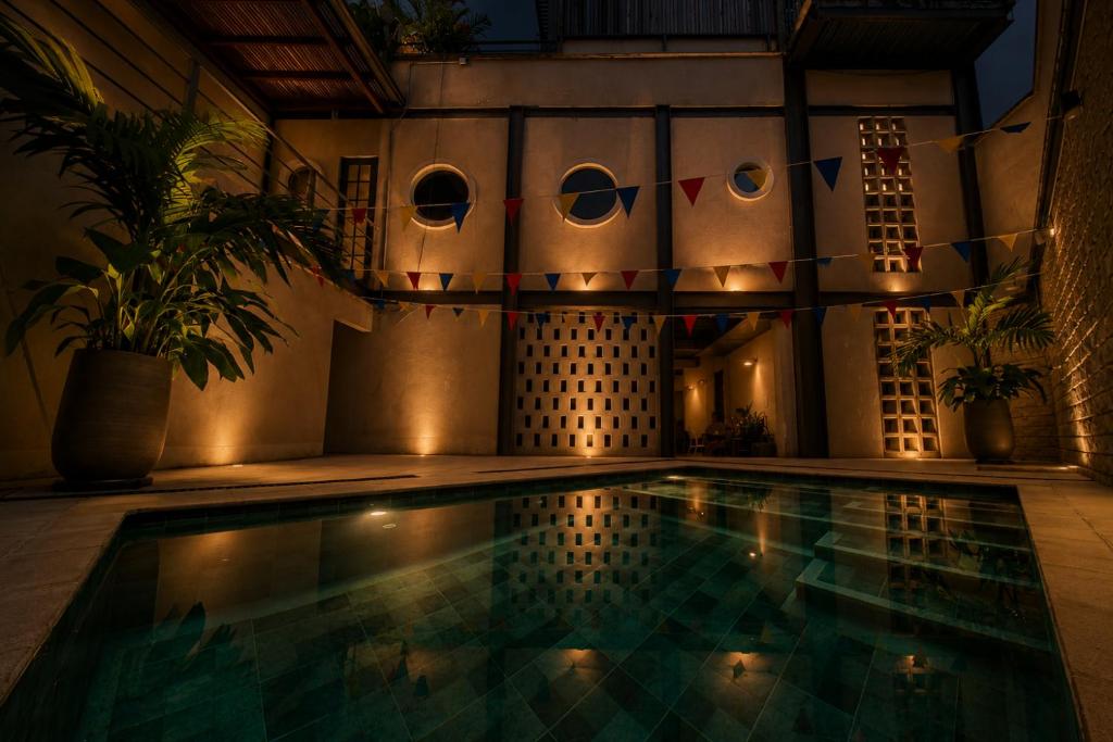 a swimming pool in a house at night with lights at Capybara Hostel - Boutique hostel in Villavicencio