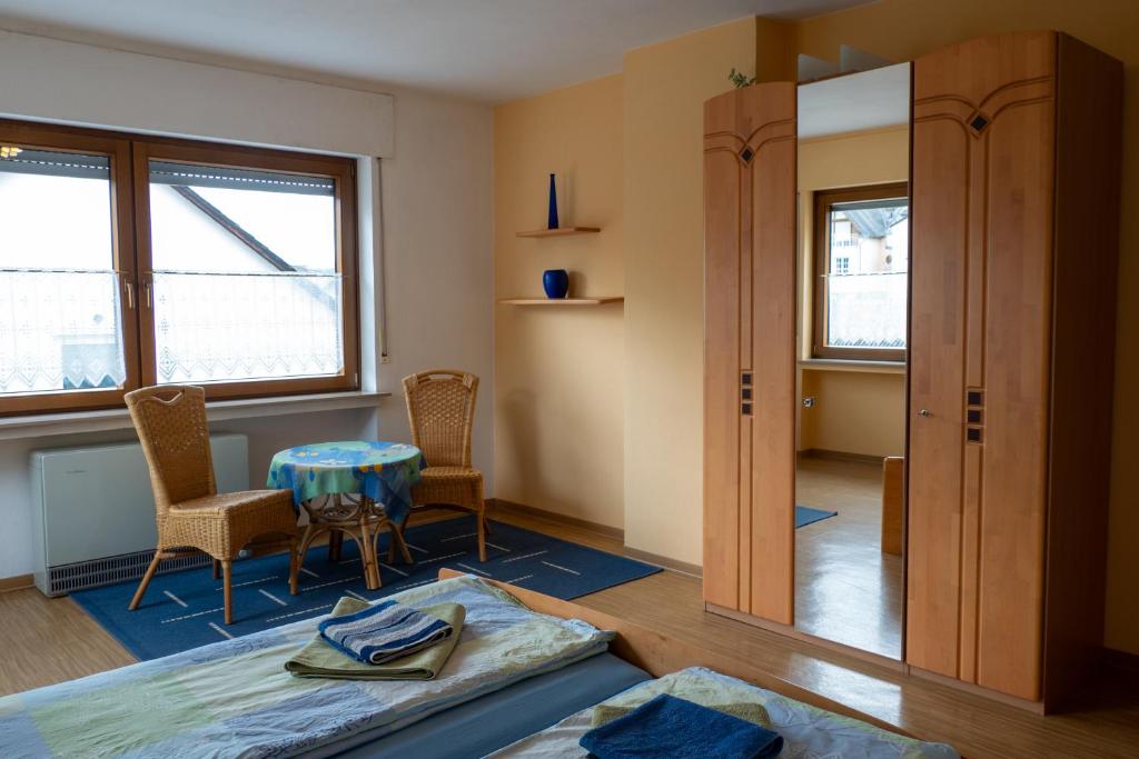 a room with a bed and a table and chairs at Ferienwohnung Weißburgunder in Klüsserath