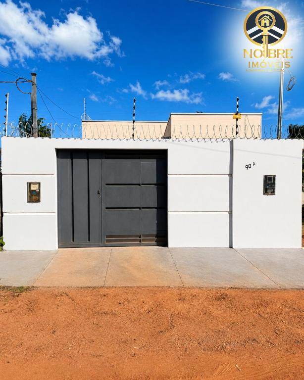 a white garage with a black door at Casa completa com 2 quartos no Bairro Alvorada in Santarém
