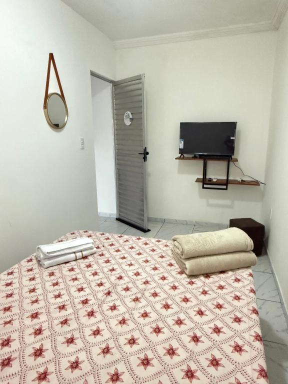 a bedroom with a bed and a television in it at Estadia rápida - Quarto 2 in Bayeux