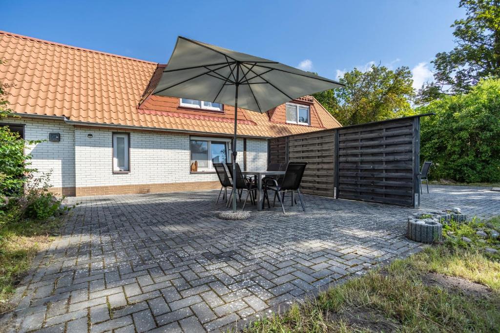 a patio with a table and chairs and an umbrella at Ankerhaus 2 in Trent