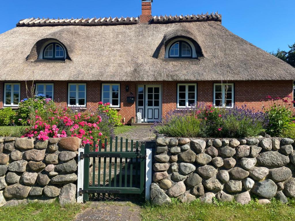 a brick house with a gate and a stone wall at Ferienwohnung Piesch in Glücksburg