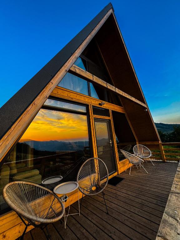 a group of chairs on the deck of a house at Joy Chalet in Plaiu
