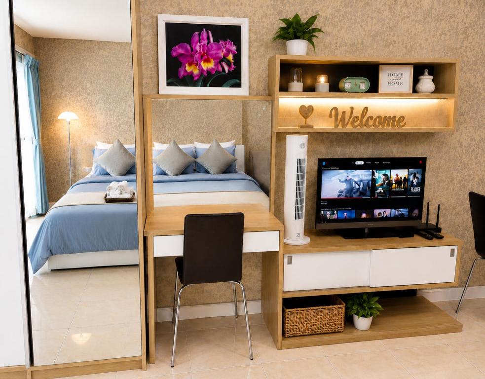a bedroom with a bed and a desk with a television at Modern 12th Floor Condo Walk to Phuket Old Town with Pool & Gym in Phuket