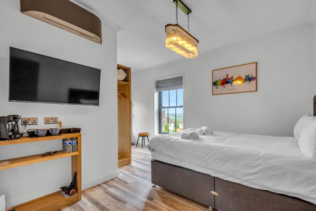 a bedroom with a large bed and a flat screen tv at Larkey View A Tranquil Space For Two - Pass the Keys in Canterbury