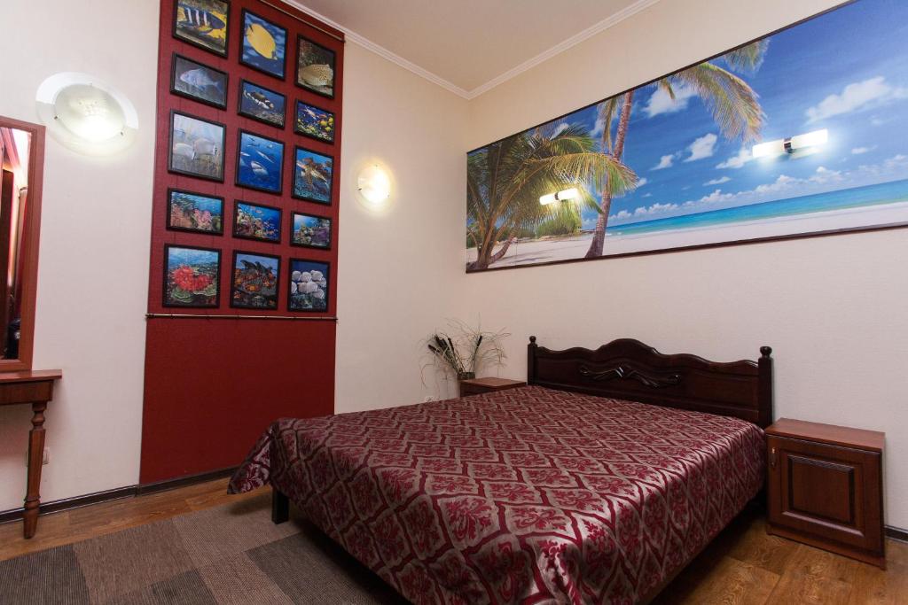 1 dormitorio con 1 cama y una gran pintura en la pared en U Igorya Holiday Park, en Alushta