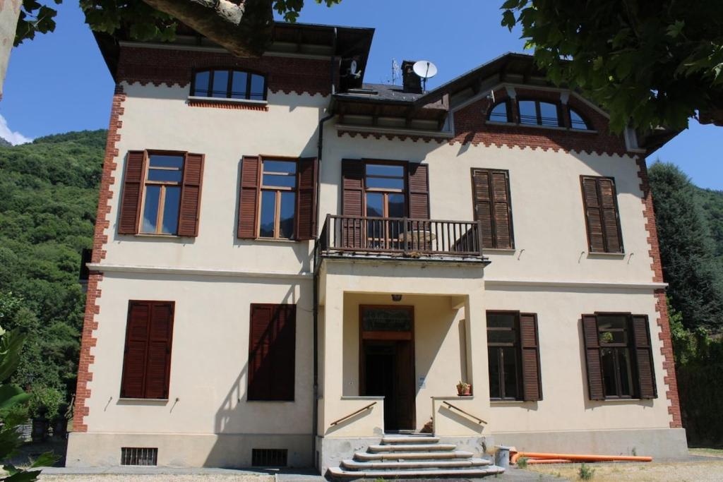 a large white building with a balcony on it at Villa Gina in Villar Pellice