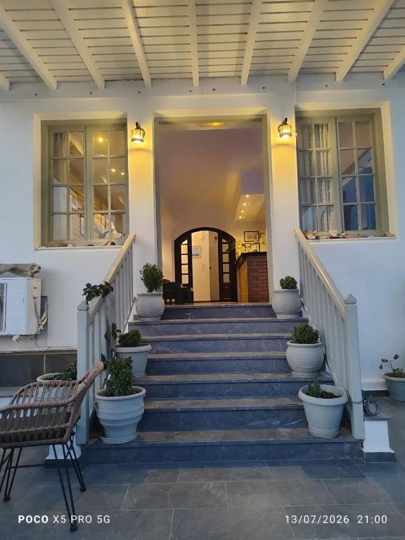 a porch of a house with stairs and a bench at Hotel Apartments Giannis in Adamantas