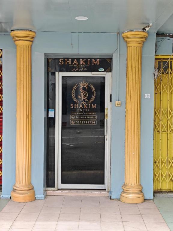 a door to a sharma restaurant with two columns at Shakim hotel in Cukai