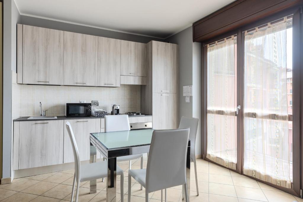 a kitchen with a dining room table and chairs at Turin Airport apt G in Leinì