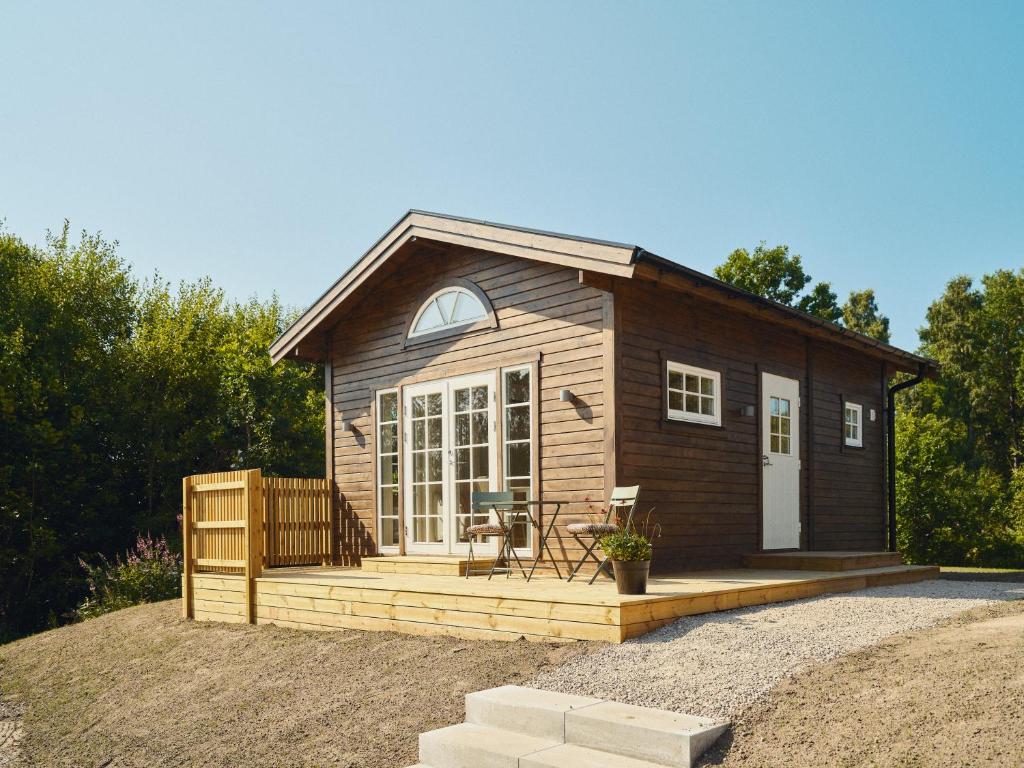 a tiny house with a porch and a deck at Lakeside Herrestad in Värnamo