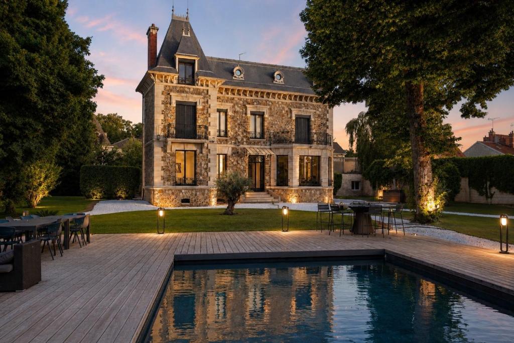 an estate with a swimming pool in front of a house at Maison de Maître en Champagne in Vitry-le-François