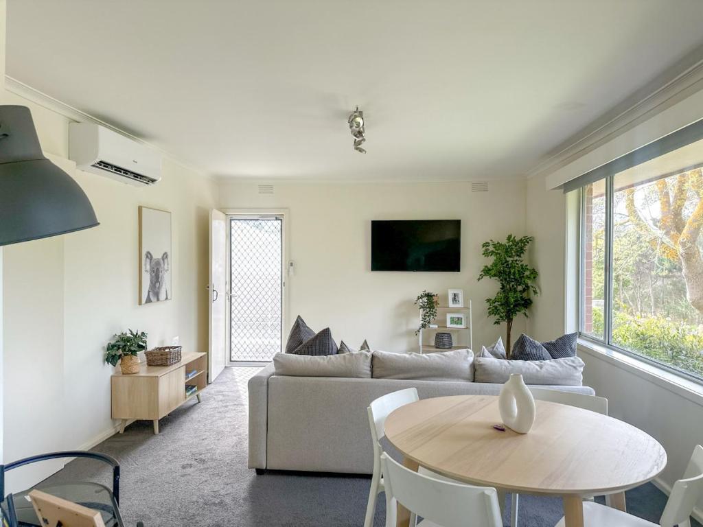 a living room with a couch and a table at Cozy & Spacious Family Unit Mt Martha in Mount Martha