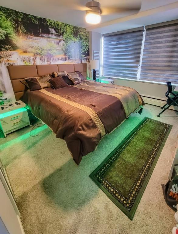 a bedroom with a large bed with a green rug at The River Condos in Detroit