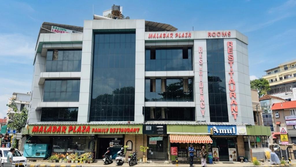 a building on a city street with motorcycles in front at Hotel Malabar Plaza in Cochin