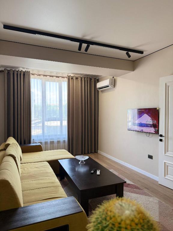 a living room with a couch and a table at Lux Residence 2 in Osh