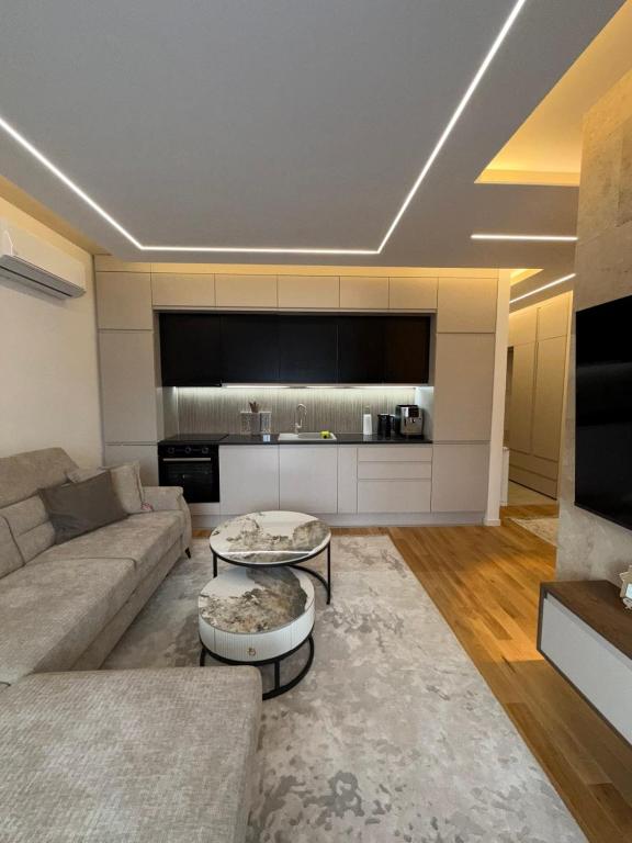 a living room with a couch and a table at Emma Luksuzni apartman Tuzla Musique in Tuzla