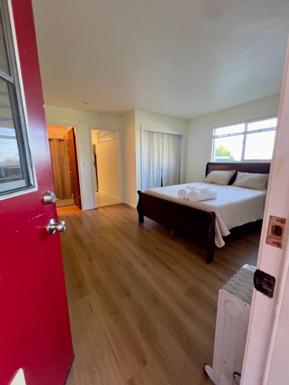 a bedroom with a large bed and a red door at Charming studio one mile from beach in Aptos