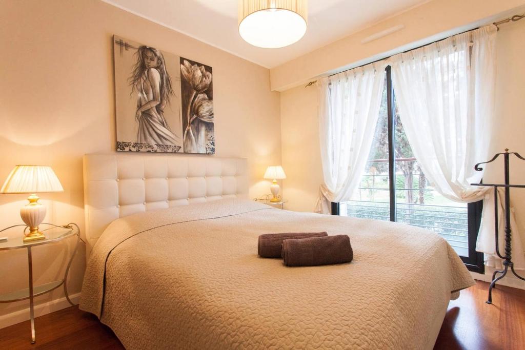 une chambre avec un lit et une grande fenêtre dans l'établissement Carlton Riviera Apartment, à Cannes