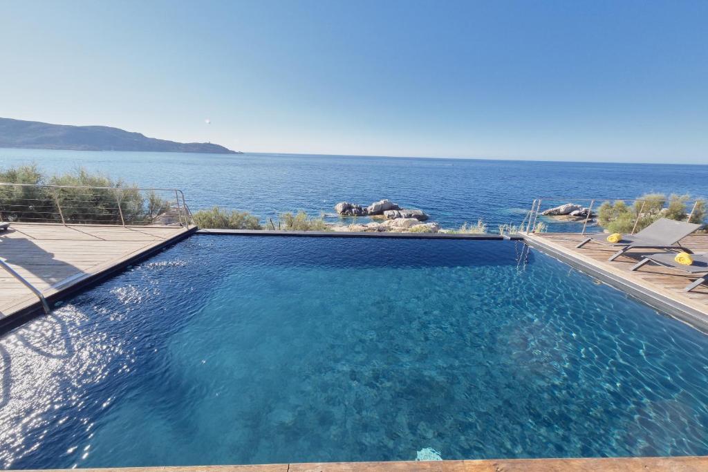 a swimming pool with a view of the ocean at Cala Di Mare Villa in Calvi