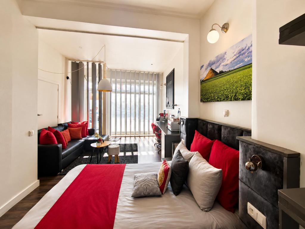 a bedroom with a large bed with red pillows at La tête dans les nuages - Chez Léa in Braine-lʼAlleud