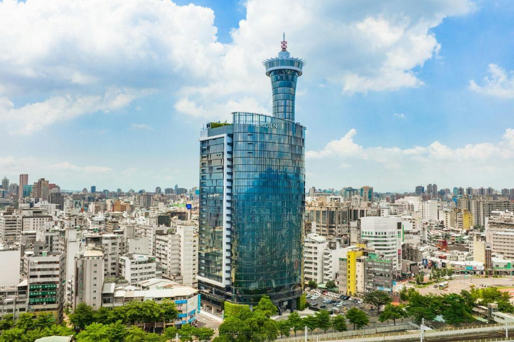 a tall building with a tower in a city at Le Meridien Taichung in Taichung