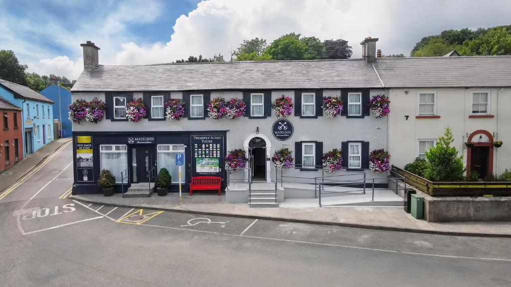 a white building with flowers on the side of it at Madelines Accommodation in Tinahely