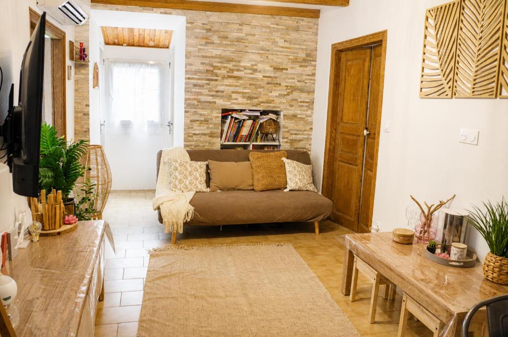 a living room with a couch and a table at Charmant appartement climatisé en plein coeur du village et proche des plages avec wifi in Cervione