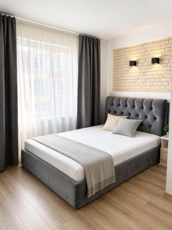 a bedroom with a large bed with a large window at Mis apartamentai in Mažeikiai