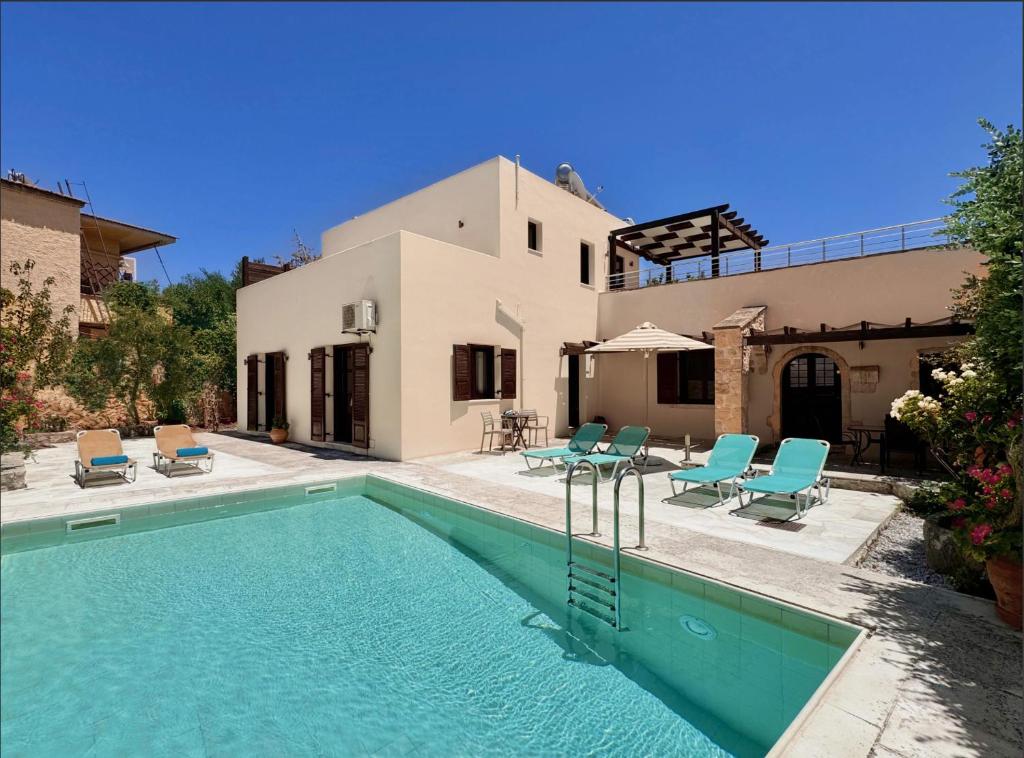 a villa with a swimming pool and a house at Villa Argiro Plaka Crete in Plaka