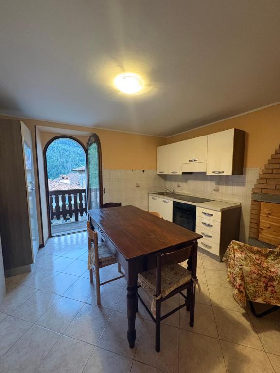 a kitchen with a wooden table and an open window at CASA SAN MICHELE in Bovegno