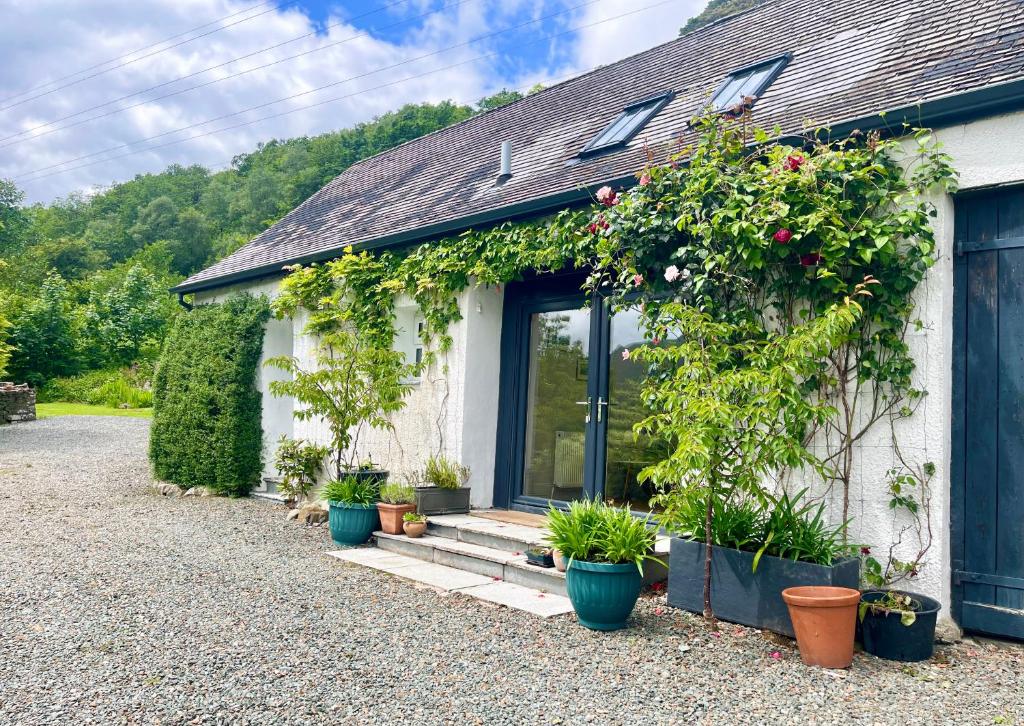 a white house with plants on the side of it at Cuil Steading in Cairndow
