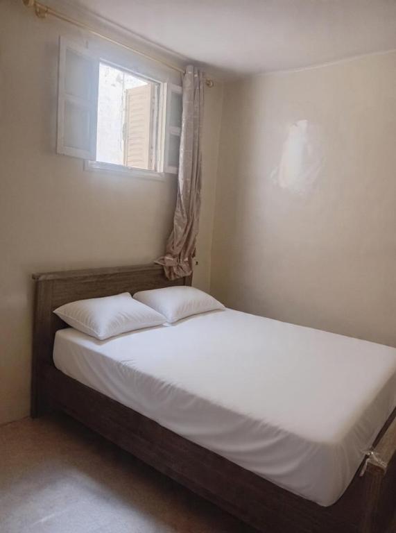 a bed with two pillows in a bedroom with a window at Dar Al Medina in Casablanca