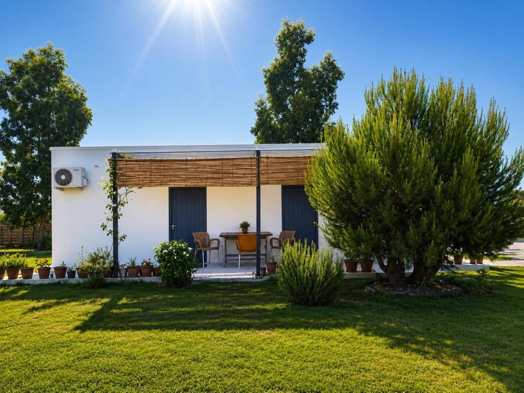 a small white house with a yard at The Pine House in Fier