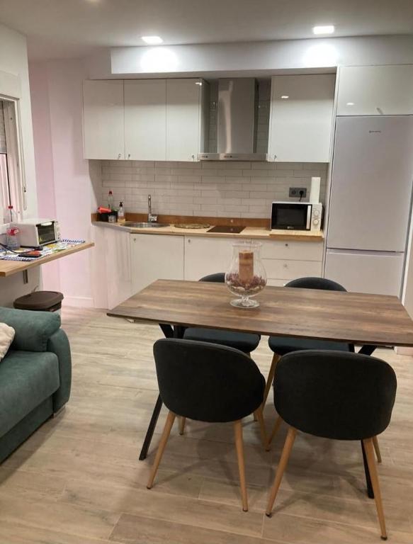 a kitchen with a wooden table and some chairs at Apartamento Hércules in Ceuta