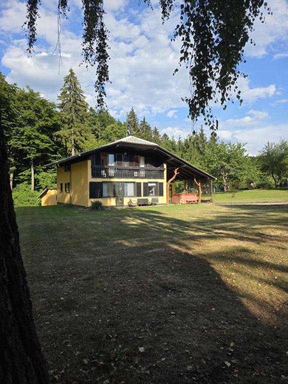 a large house with a large yard in front of it at Kopitnik cosy cabin in Dol pri Hrastniku