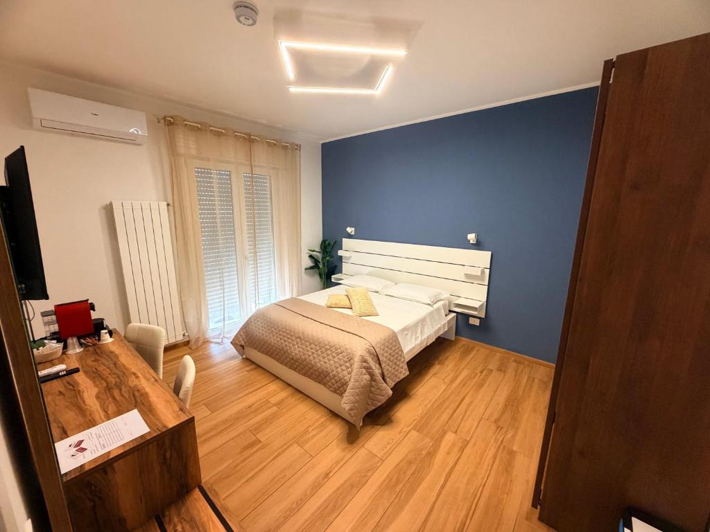 a bedroom with a bed and a blue wall at Palazzo del Toro 2 in Montesilvano