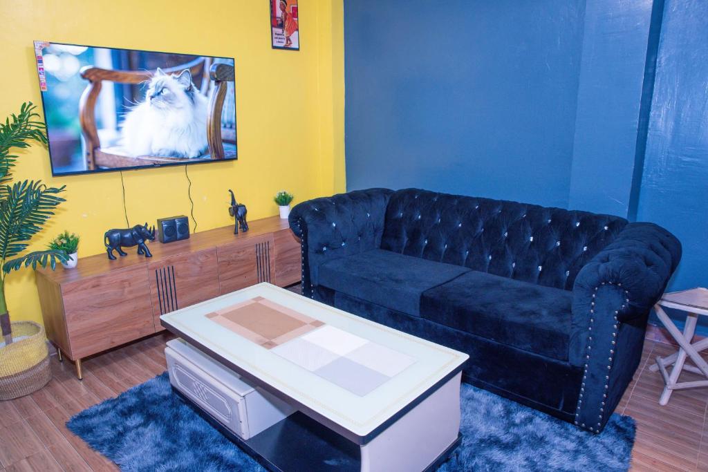 a living room with a blue couch and a tv at Micasa Homes BNB GF in Limuru