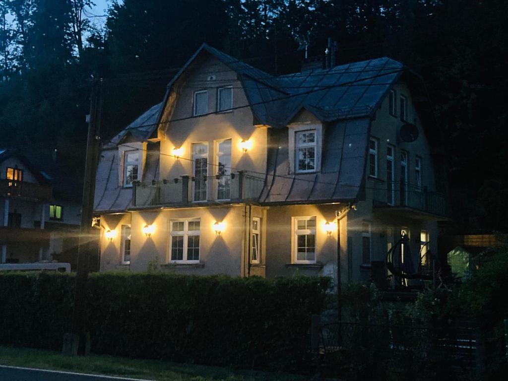 a house with lights on the front of it at night at Dworek Ewunia in Wisła
