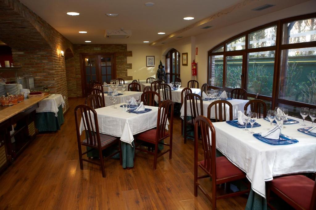 a restaurant with tables and chairs with white tablecloths at El Tejo de Comillas in Comillas