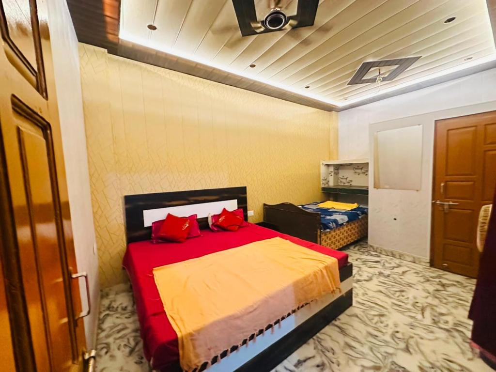 a bedroom with a bed with red pillows on it at Lakshman Guest House Ayodhya in Jāmb