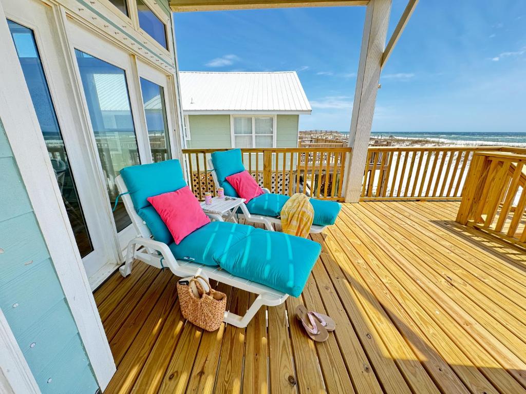 a porch with two chairs and a table on a deck at Oceanfront/Zero Steps to Beach/Views/4BR in Gulf Shores